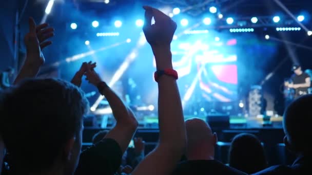 Jeunesse active applaudissant avec les bras levés au-dessus de la tête sur l'événement de la musique en direct dans lumineux éclairé par des projecteurs — Video