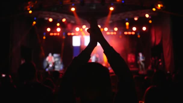 Silhouette de l'homme applaudissent et sautent sur fond de foule lors d'un événement nocturne au ralenti — Video