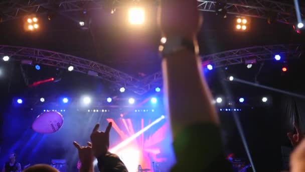 Ruce zvednuté v jasném světle před jevištěm na rockovém koncertě ve zpomaleném filmu — Stock video