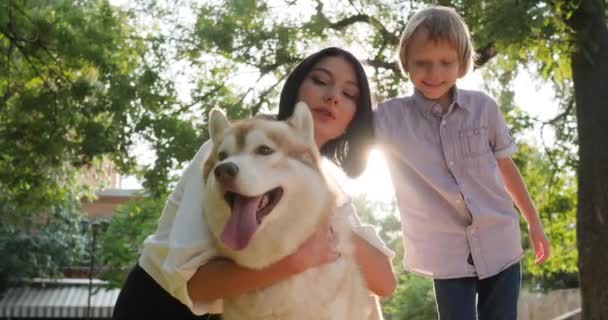 Familie en huisdier, vrouw knuffelen husky hond close-up op de achtergrond van de natuur en kind — Stockvideo