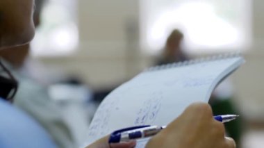 Test, kadın elinde bir kalem ve bir kağıt tutuyor.