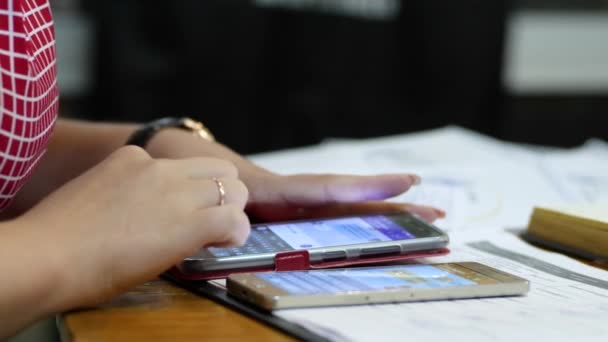 Mujer de negocios utiliza un dispositivo móvil en un escritorio en una sala de conferencias, las manos de cerca — Vídeos de Stock