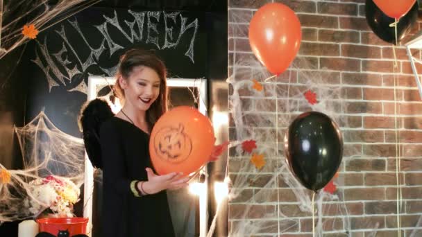 Halloween-Feier, junge Hexe spielt Luftballon mit Kürbis, Teenie-Mädchen im Gruselkostüm — Stockvideo
