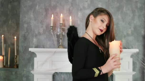 Mladá čarodějnice se svíčkou, halloween oslava, mystická atmosféra, dospívající v kostýmu temných andělů — Stock video