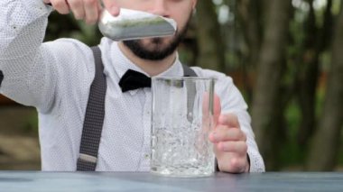 İş yerindeki barmen bardağa buz koyardı, bardaki barmen içki için bardağa buz koyardı.,