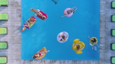 Yaz tatili, mayo giymiş güzel kızlar, tatil köyünde havuz kenarında dinlenirken akıllı telefonlarda selfie çekiyorlar.