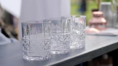 Barmen bardağa buz ekler, barmen müşteriye içecek yapar, barmen de buzlu kokteyl yapar.
