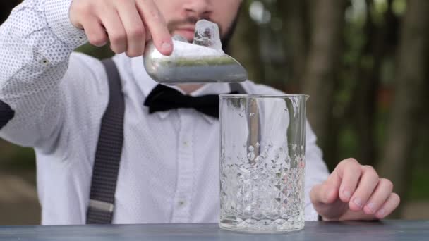 Barman hombres añade cubitos de hielo en vidrio para el alcohol, barkeeper poner cubitos de hielo en vidrio en el mostrador de bar , — Vídeos de Stock