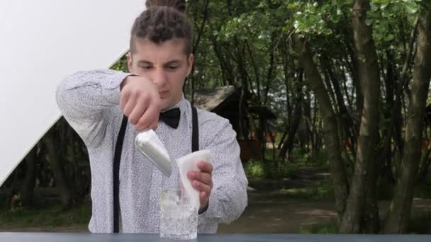 Bar worker vierte cubitos de hielo en un vaso de precipitados vacío, barman preparando cóctel, cubitos de hielo mezclando cuchara de bar — Vídeos de Stock