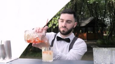 Barmen hazır şarap bardağına likör karıştırıyor, barmen kokteyl hazırlıyor.