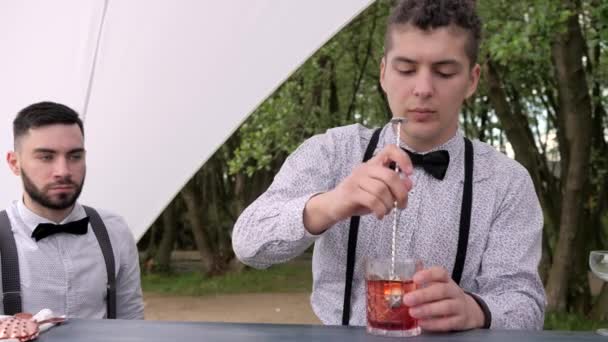 Barägare blandar sked cocktail för kunden, barmens bakom bar, bartender gör cool dryck i glas — Stockvideo