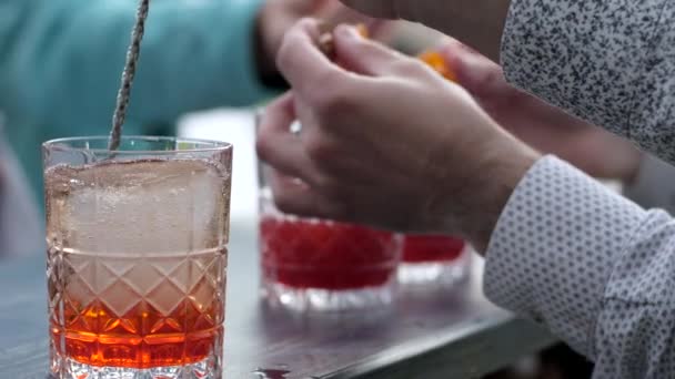 Barkeeper stirs alcohol in glass, barman makes beverage for client, hands bartender makes glacial cocktail — 비디오