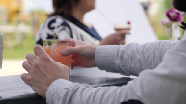 Cafetería en la terraza de verano, bebidas de la subvención del cliente, camarero hace cóctel de color en vidrio, camarero detrás de la barra — Vídeos de Stock