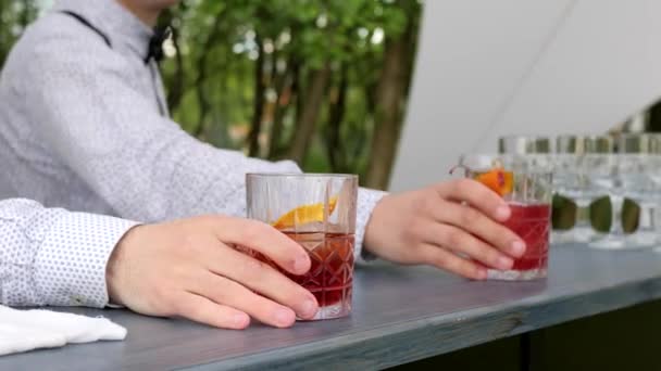 Handen barmannen achter de bar serveert cocktail voor de klant, close-up, barman het maken van koele drank in glas — Stockvideo