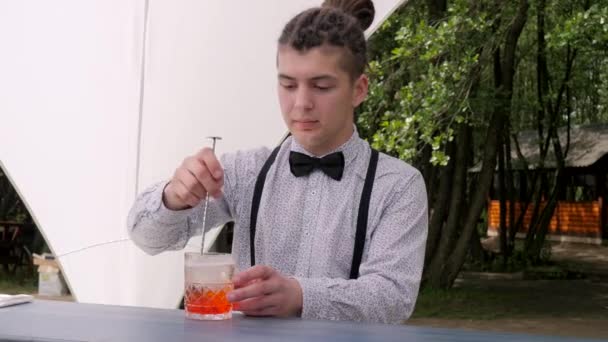 Tapster mezcla de vidrio bar cuchara cubitos de hielo con ron, barman preparación de cóctel alcohólico, trabajador del bar hace mezcla de bebidas — Vídeos de Stock