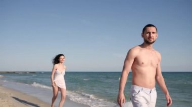 Tatilde bir çift, koşuya çıkmış bir kız, okyanus kıyısında rüzgar saçlarını, tropikleri geliştiriyor.