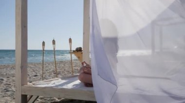 Plajda meditasyon yapan bir kız, tatil köyünde yaz tatili yapan bir kadın, sette yoga yapan bir kadın.,