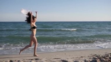 Arka planda kumsalda koşan seksi kadınlar, özgür mutlu kadın, mayo giymiş mutlu kız.,