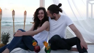 Kokteylli romantik çift plaj köşkünde egzotik bir tatil, tropik meyveler, yanan meşaleler
