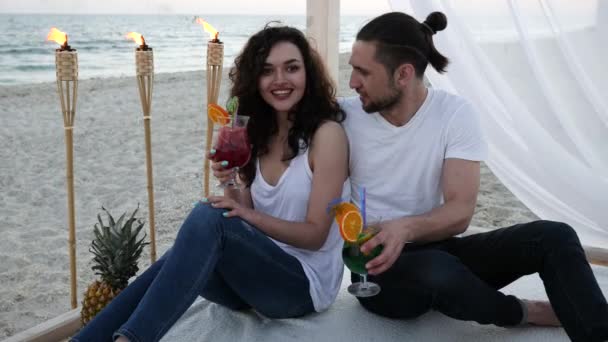 Romantic summer vacations for Lovers guy and girl, Tropics, couple with cocktails have fun at beach bungalow with white cloth — Stock Video