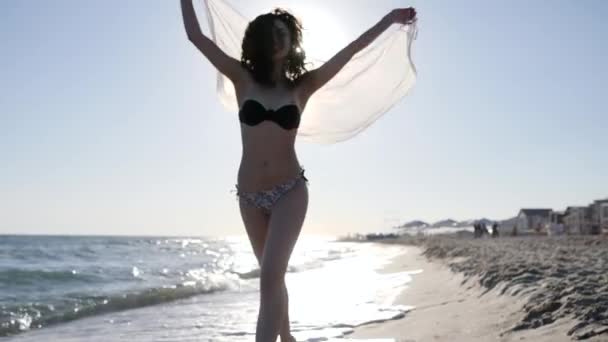 Mujer corriendo en la playa en contraluz, cámara lenta, chica feliz en traje de baño, arena de fondo y el mar, corriendo a lo largo de la playa , — Vídeos de Stock