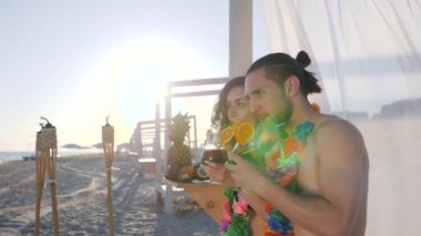 Plajdan gelen selfi adam ve kız egzotik bir tatil köyü, tropik adalardan hatıra fotoğrafı, arkadaşlar kokteyl içer ve cep telefonuyla fotoğraf çeker.