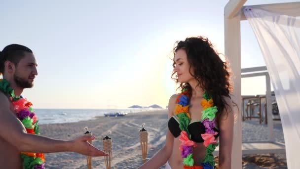 Dansen op het strand in achtergrondlicht, huwelijksreis van geliefden op tropische eilanden, zomervakantie van het liefdespaar in een exotisch resort, — Stockvideo