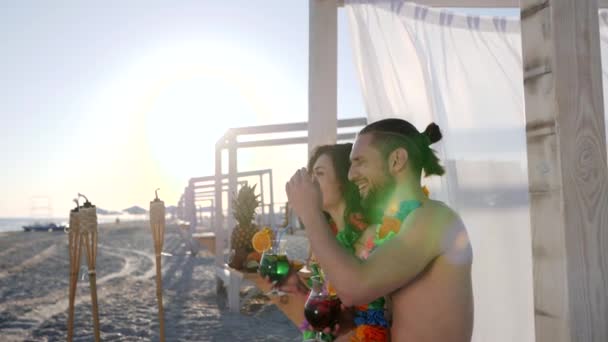Romantisch datum van paar wat zit op het strand, man zit in de buurt van meisje en punten hand in hand afstand, — Stockvideo
