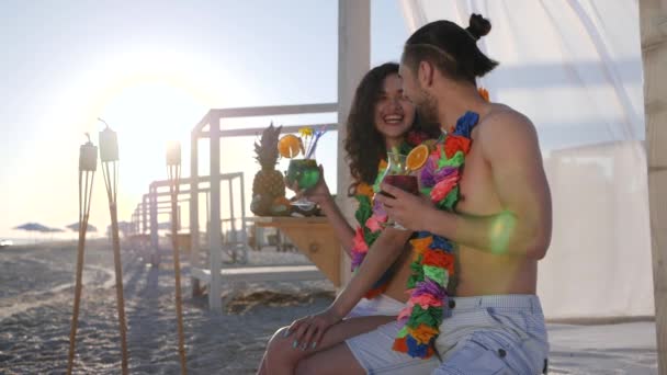 Sommar helg på tropisk resort, skrattande kvinna med man från halsband blommor på halsen, ungdomar har vila Hawaiian beach party, — Stockvideo