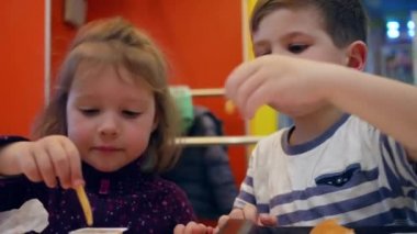 Sevgili kardeşlerim lokantada çıtır çıtır patateslerle abur cubur yer küçük kız ve oğlan için soslu patates kızartması yer.,