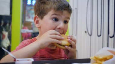 Küçük çocuk, küçük çocuk restoranında iştahla yer, güzel bebek yer, çocuk masada zararlı yemeklerle oynar.,