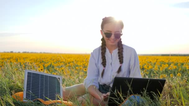 Природна енергія, щаслива молода жінка, що застосовує сонячні фотоелектричні панелі на відкритому повітрі, жінка підсвічується ноутбуком — стокове відео