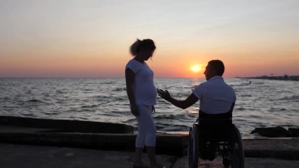 Pareja de primer plano abrazando la noche, persona con discapacidad y futura madre mirando a la distancia — Vídeos de Stock