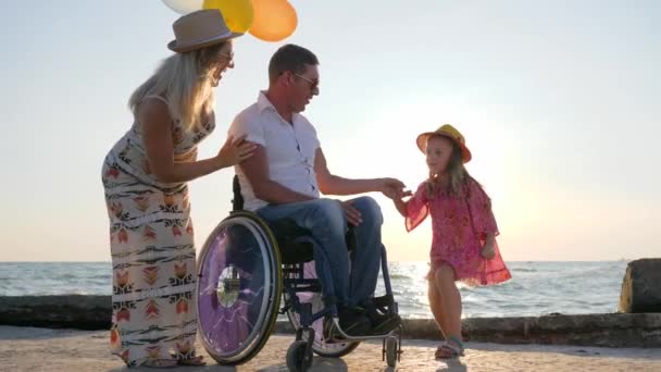 Inválido, esposa embarazada y su hija tienen un buen rato con globos de aire de colores, familia con niño — Vídeos de Stock