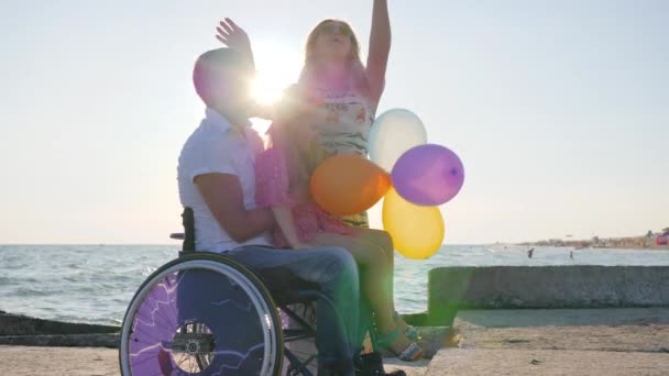 Mom and father hugging daughter in backlight, parents with child on open air, happy daughter sitting on dad — Stock Video