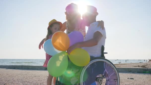 Zwangere vrouw met meisje en gehandicapte op zee, ouders met kind in de open lucht, moeder en dochter — Stockvideo