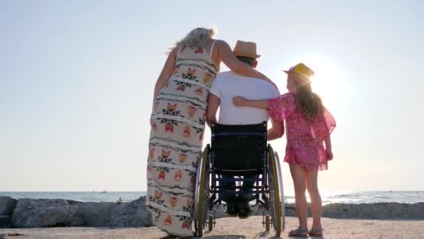 Weekend met familie, invalide met zwangere vrouw en kind steek de hand op, echtgenoot in rolstoel knuffel vrouw en klein meisje — Stockvideo