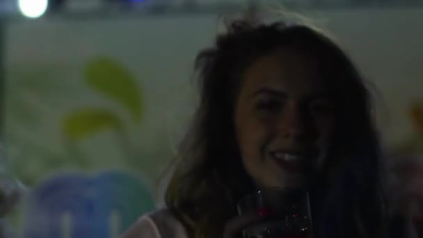 Крупный план счастливая девушка танцует в ночном клубе со стеклянным коктейлем, красивая женщина с напитком на вечеринке в синем свете — стоковое видео
