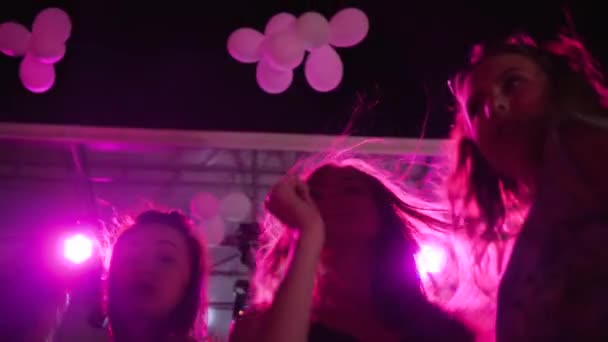 Novias bailando en discoteca, mujeres jóvenes bailando y manos arriba en discoteca en cámara lenta, luces lumiere — Vídeo de stock