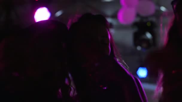 Vida nocturna, mujeres felices bebidas durante el baile en la fiesta nocturna, niñas bailan con bebidas en la fiesta en luces lumiere — Vídeos de Stock