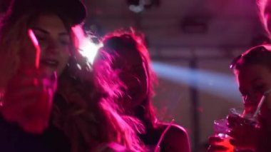 Gençler disko kulübünde, genç insanlar gece kulübünde, gece hayatında, mutlu kadınlar dans ederken içiyor.