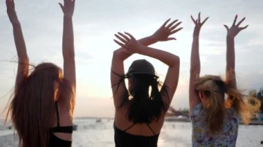 enjoyment of life, happiness young women dance on background shiny sea in vacation, girls have fun on embankment, best girlfriends dancing