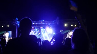 Ukrayna bayrağını sallayan güzel Ukraynalı kadın, rock konserindeki insanlar