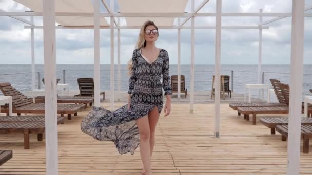 Teure Urlaube von Frauen an der Küste Meer, Frau mit Sonnenbrille Spaziergänge entlang Steg in der Nähe des Meeres, langhaarige Mädchen — Stockvideo