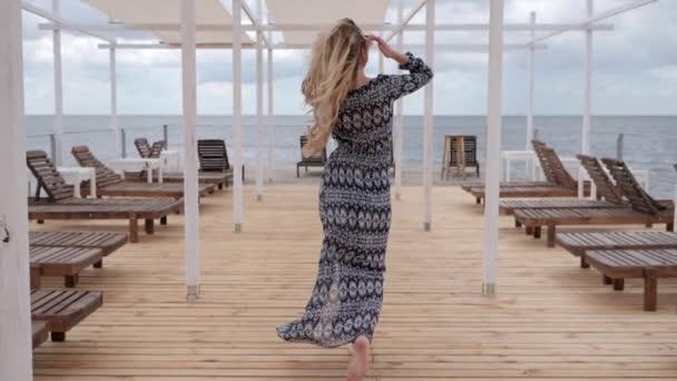 Feliz mujer llamándola, vacaciones de verano de las mujeres en la playa, chica en el desarrollo de la ropa en el viento en el paseo marítimo, mujer joven ir descalza — Vídeos de Stock