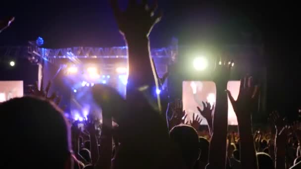 Braços levantados de pessoas em luzes brilhantes no festival de rock, fãs acenando as mãos na festa de concerto , — Vídeo de Stock