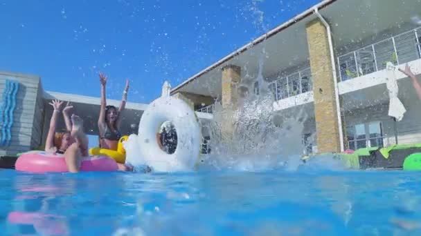 Amigos felizes nas férias de verão, companhia de meninas em anéis infláveis relaxando e se divertindo na piscina no resort durante o fim de semana — Vídeo de Stock