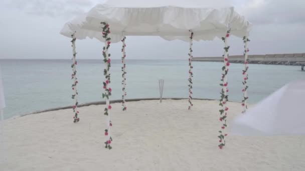 Весільна арка прикрашена квітами на океанічному пляжі проти неба та води на екзотичному курорті — стокове відео