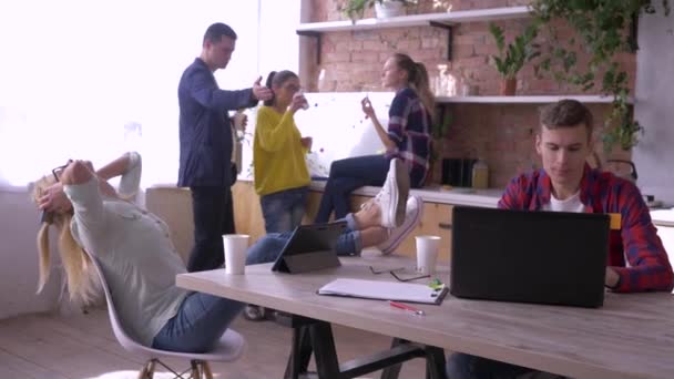 Успешная команда офисных людей питается и работает с планшетами и ноутбуками в кухне во время создания нового творческого проекта в офисе — стоковое видео