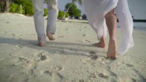 Romantischer Trip, junges Paar mit nackten Füßen im Luxusurlaub am nassen Sand entlang — Stockvideo